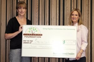 Board member Stacy Chaput presents Malinda Coss from the Salvation Army with a $5,000 grant to help with Muskegon River Flooding.