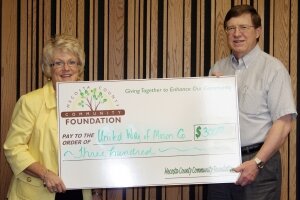 Board member Yo Bellingar presents Paul Griffith from 2-1-1 Information and Referral with a grant for $300!
